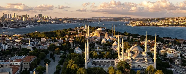 Historic Istanbul peninsula, mosques, Bosphorus and modern skyline in warm late-day light.
