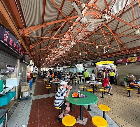 Tables, customers and stalls beneath Maxwell Food Centre’s roof.